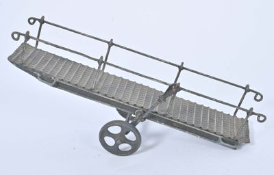 un petit train avec un pont dessus, posé sur une surface blanche