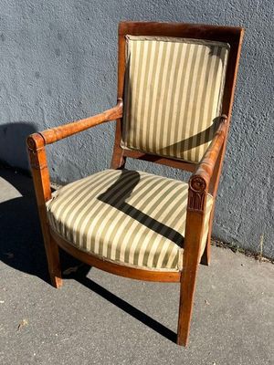 une vieille chaise en bois dont l'assise est recouverte d'un tissu rayé