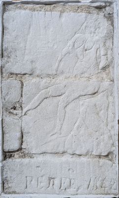 une plaque en pierre fixée sur le côté d'un mur de briques