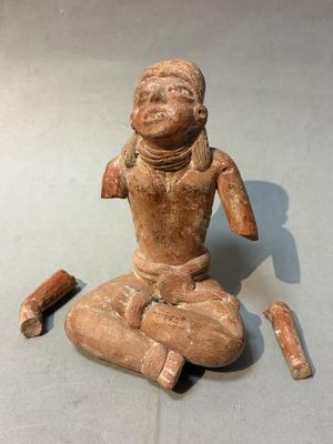 an image of a statue of a person sitting on a floor next to a hammer
