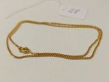 un collier en or auquel est attachée une chaîne