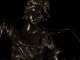 bronze statue of a woman holding a bird on a black background