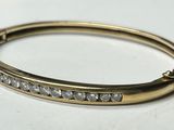 a close up of a gold bracelet with diamonds on it
