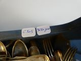 a lot of spoons and forks in a bowl with a note on it