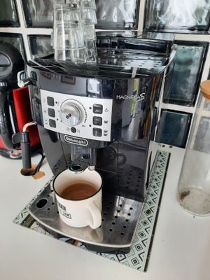 a coffee maker that is on a counter with a cup of coffee