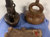 three pieces of pottery sitting on a blue cloth on a table