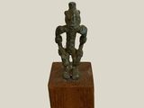 an image of a bronze statue of a man on a wooden block