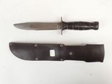 a knife that is laying next to a knife sheath
