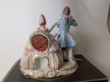 a figurine of a man and a woman sitting on a chair