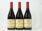 trois bouteilles de vin sont alignées sur une surface blanche
