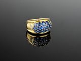 a close up of a gold ring with blue sapphires and diamonds