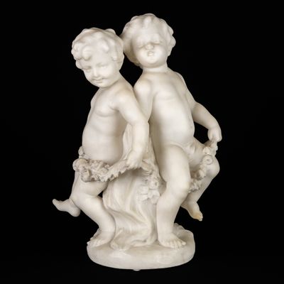 une statue blanche représentant deux enfants assis sur un rocher