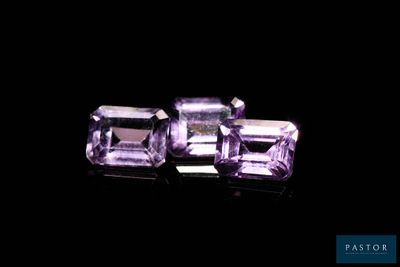 two purple amethtites sitting on top of a black surface