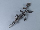 une broche en argent surmontée d'un oiseau