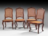 un ensemble de quatre chaises de salle à manger de style Louis II à dossier en rotin