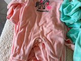 pink and blue onesuits are laying on the floor next to each other