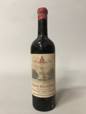 une bouteille de vin rouge posée sur une table blanche