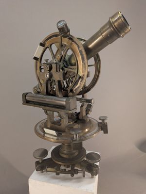 un télescope d'aspect très ancien, posé sur un trépied sur une table