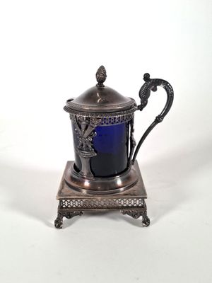 théière plaquée argent sur un socle, contenant du verre bleu