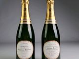 two bottles of champagne sitting next to each other on a table