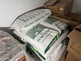 a pile of bags of cement sitting on top of a pile of boxes