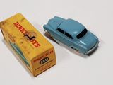 a blue toy car next to a box on a white surface