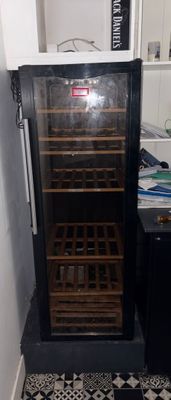 un sol carrelé noir et blanc dans une cuisine équipée d'une cave à vin