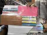 une pile de livres posée sur une palette, à côté d'une pile de cartons