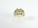 a close up of a gold ring with emeralds and diamonds