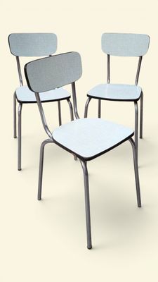 trois chaises placées côte à côte sur une surface blanche