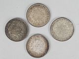 four different types of silver coins on a white surface
