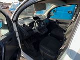 a white car with its door open next to a blue truck