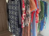 a lot of shirts hanging on a rack in a room