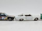 several toy cars are lined up in a row on a white surface