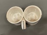 pair of white coffee cups with black and white designs on them