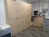 a room with a desk, cabinets, and a computer