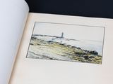 an open book with a picture of a lighthouse in the background