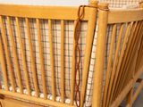 a wooden crib with a plaid blanket on it