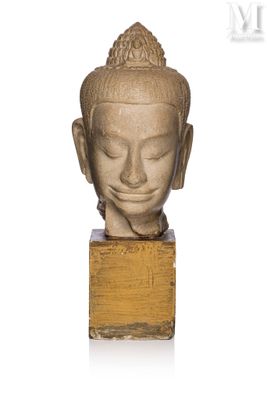 statue of a buddha head on a wooden base on a white background