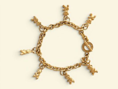 a close up of a gold bracelet with charms on it