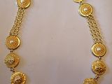 gros plan d'un collier en or sur une surface blanche