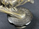 bronze figurine of a woman on a surfboard on a black surface