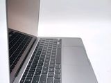 a silver laptop with a black keyboard on a white surface