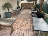tables and chairs are lined up on a brick patio