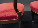 pair of red velvet upholstered chairs with black legs