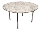 une table en marbre blanc avec des pieds chromés et un plateau rond