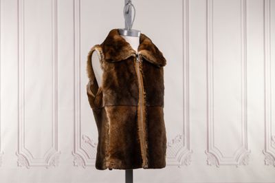 an image of a fur vest on a mannequin stand in front of a white wall