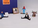 several figurines of people sitting in front of a blue box