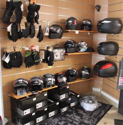 many helmets and gloves hanging on the wall in this room