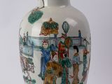 a white vase with a painting on it sitting on a table